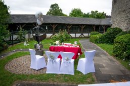 Tisch für Standesbeamten und Brautpaar im Rosengarten der Burg