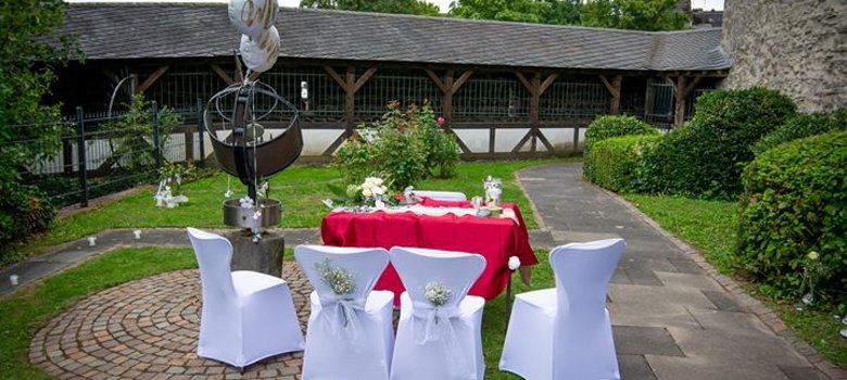 Tisch für Standesbeamten und Brautpaar im Rosengarten der Burg