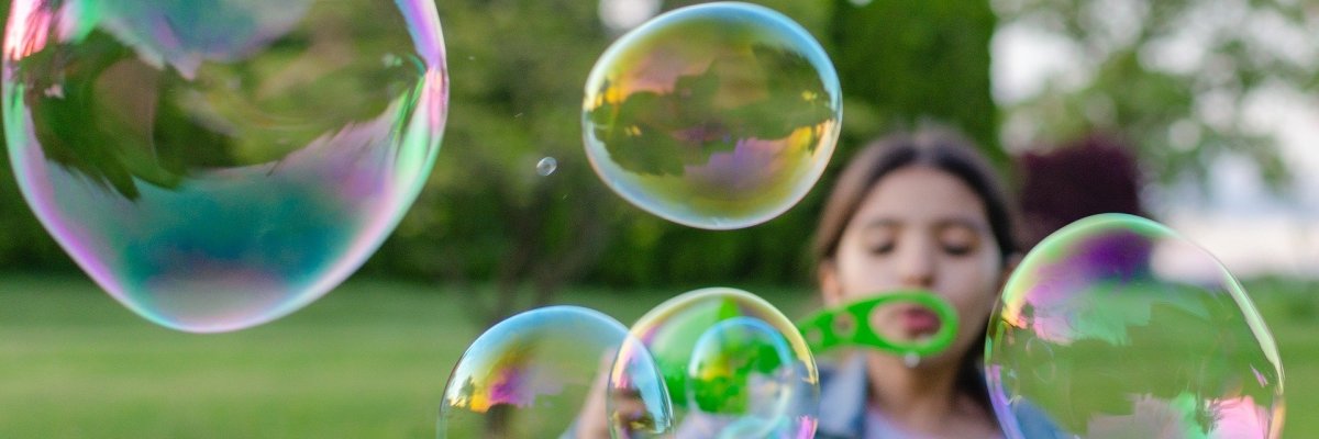 Ein Mädchen versprüht Seifenblasen