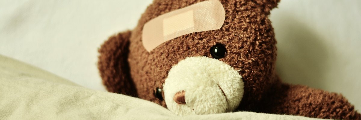 Ein Teddybär mit Pflaster auf dem Kopf