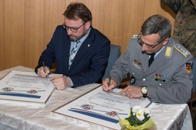 Unterzeichnung der Partnerschaftsurkunde Oberbürgermeister und Oberst unterzeichnen Urkunden