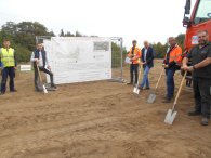 Sechs Personen mit Spaten stehen auf einem Feld.