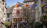 Fachwerkhäuser in der Innenstadt von Mayen bei sonnigem Frühlingswetter mit blühenden Bäumen und Blumen