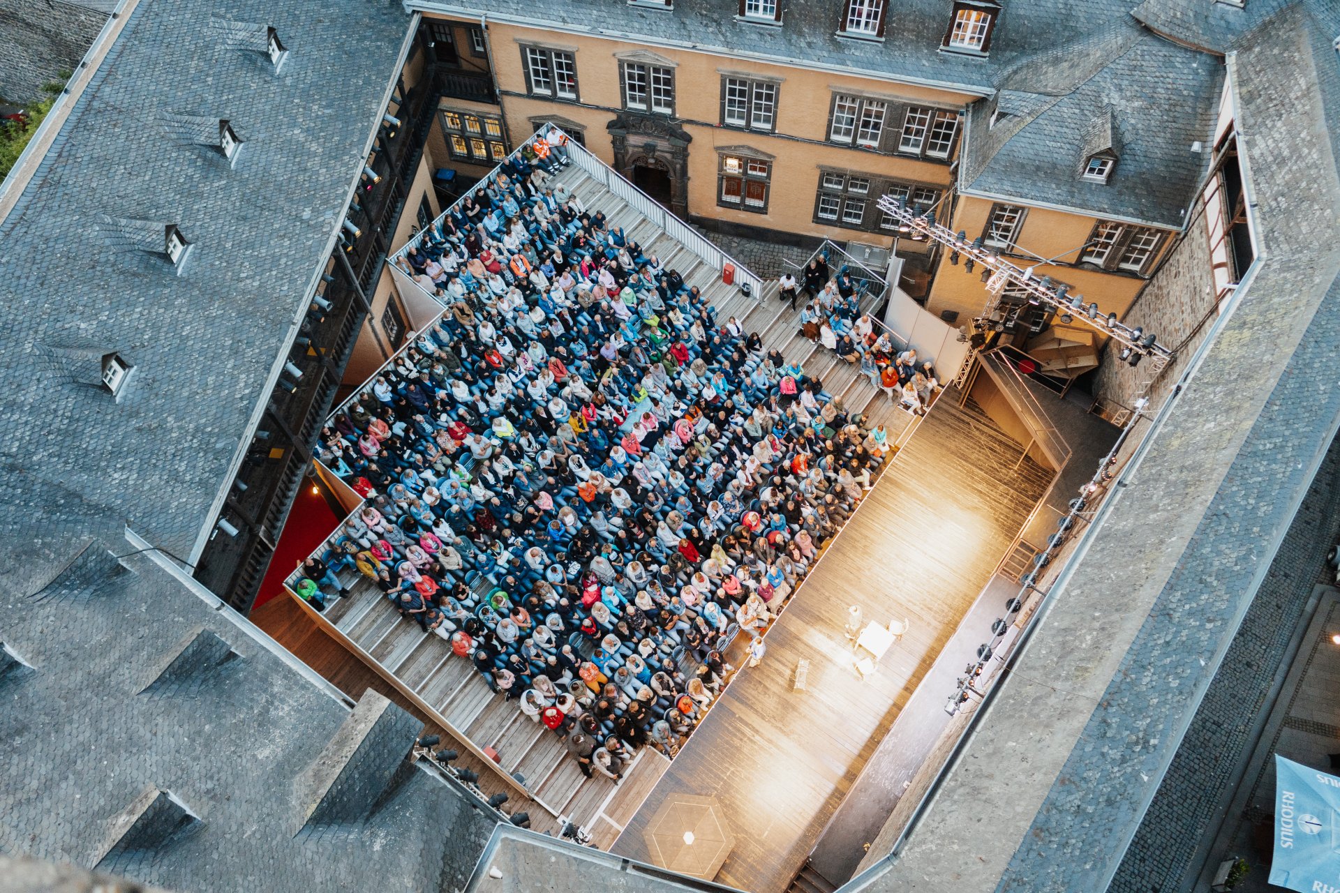 Blick von oben auf die Sitzreihen und Personen Burgfestspiele