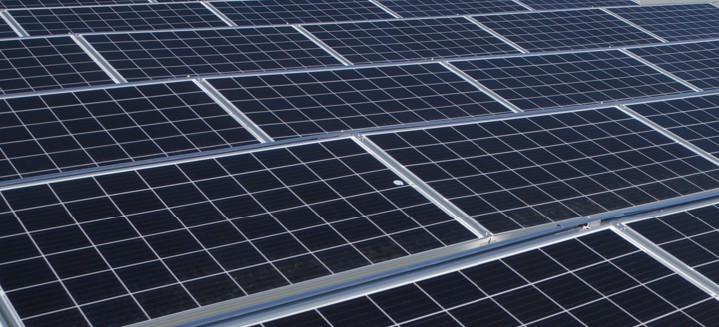 Reihen von Photovoltaikmodulen auf einem Gebäudedach, die Sonnenlicht in elektrische Energie umwandeln.