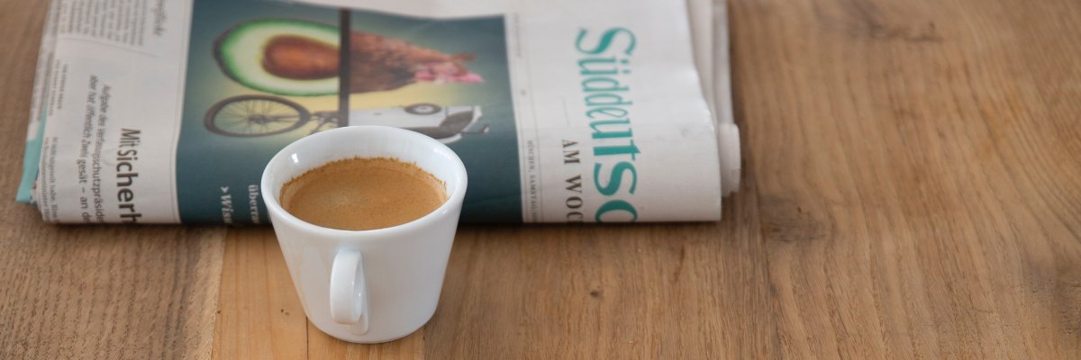Zeitungen und eine Kaffeetasse auf dem Tisch