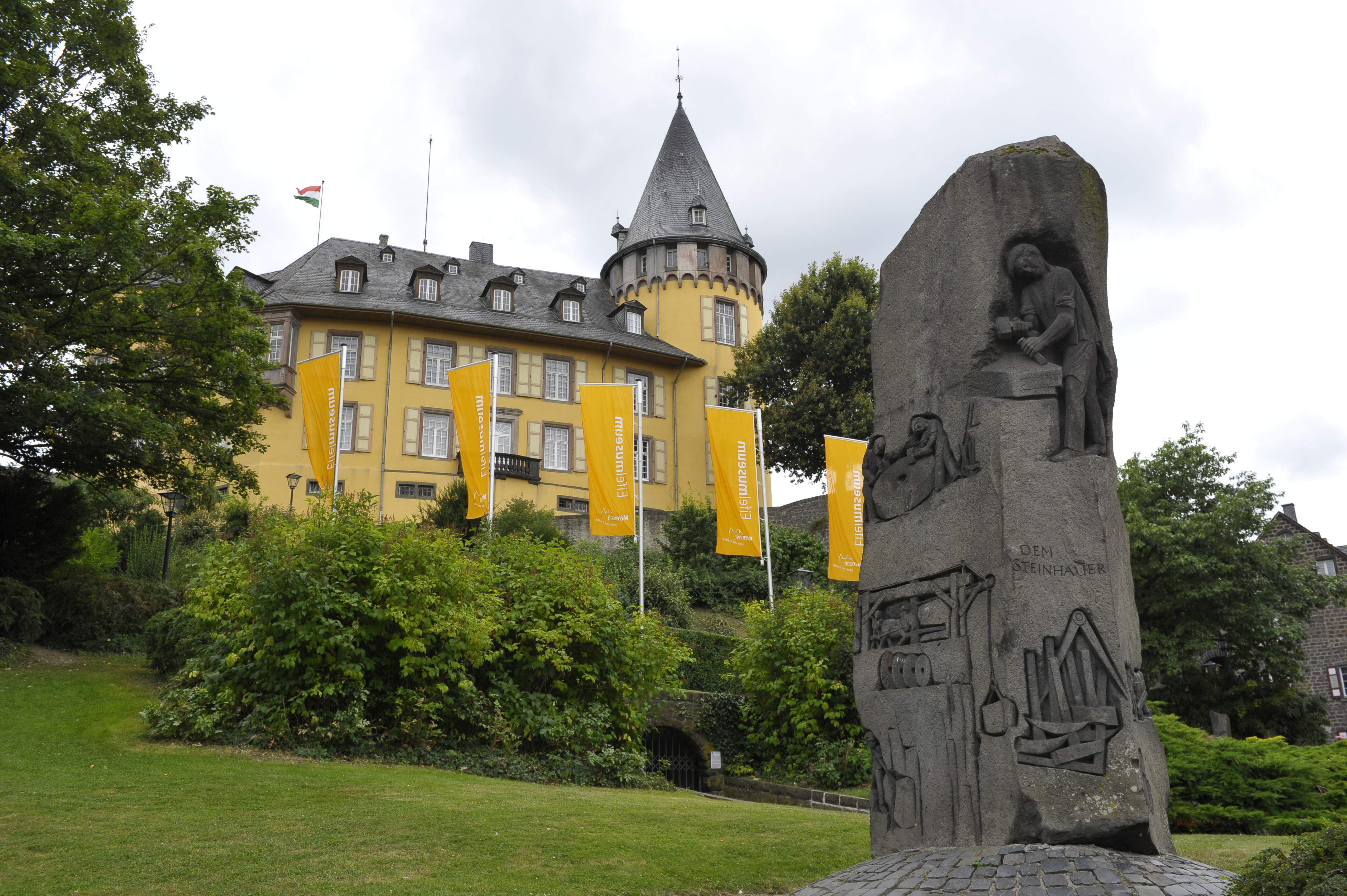 Die Schlossseite der Genovevaburg mit dem großen Basaltstein im Vordergrund.