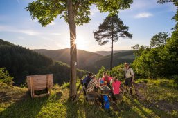 Am Picknickplatz Bleiberghütte hat man einen großartigen Panoramablick ins Nitztal. Eine Gruppe von Wanderen macht Rast am Picknickplatz Bleiberghütte. Im Hintergrund sieht man die atemberaubende Aussicht in die Wälder des Nitztals.