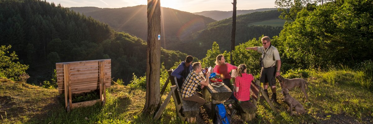 Am Picknickplatz Bleiberghütte hat man einen großartigen Panoramablick ins Nitztal. Eine Gruppe von Wanderen macht Rast am Picknickplatz Bleiberghütte. Im Hintergrund sieht man die atemberaubende Aussicht in die Wälder des Nitztals.