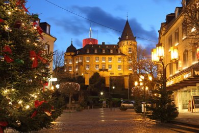 Die weihnachtlich geschmückte Genovevaburg am oberen Ende des Marktplatzes. Die weihnachtlich geschmückte Genovevaburg am oberen Ende des Marktplatzes. Die Dämmerung hat bereits eingesetzt und die Beleuchtung zaubert ein ganz besonders besinnliches Ambiente in die Innenstadt.