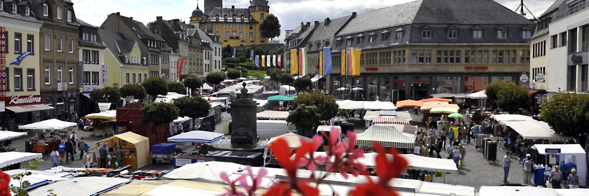 Vom alten Rathaus fällt der Blick auf den Marktplatz. Hier findet einer der vier Krammärkte des Jahres statt. Im Hintergrund ist die Genovevaburg zu sehen.