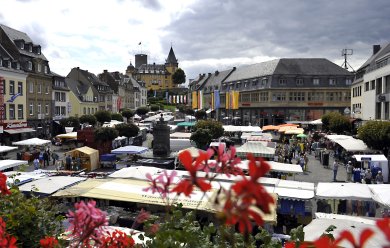 Krammarkt auf dem Marktplatz Vom alten Rathaus fällt der Blick auf den Marktplatz. Hier findet einer der vier Krammärkte des Jahres statt. Im Hintergrund ist die Genovevaburg zu sehen.