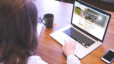 Eine Frau hat auf ihrem Laptop die Website der Stadt Mayen aufgerufen und bekommt die Online-Dienstleistungen der Stadt Mayen angezeigt.