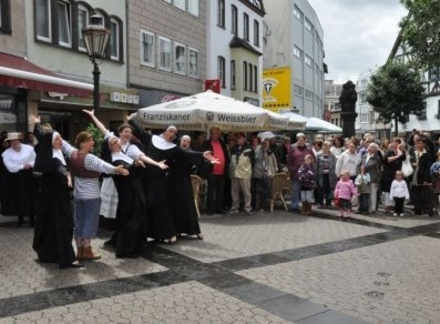 Brückenstraßenfest eine Gruppe von Tänzerinnen und Tänzern in der Brückenstraße mit Zuschauerinnen und Zuschauern im Hintergrund