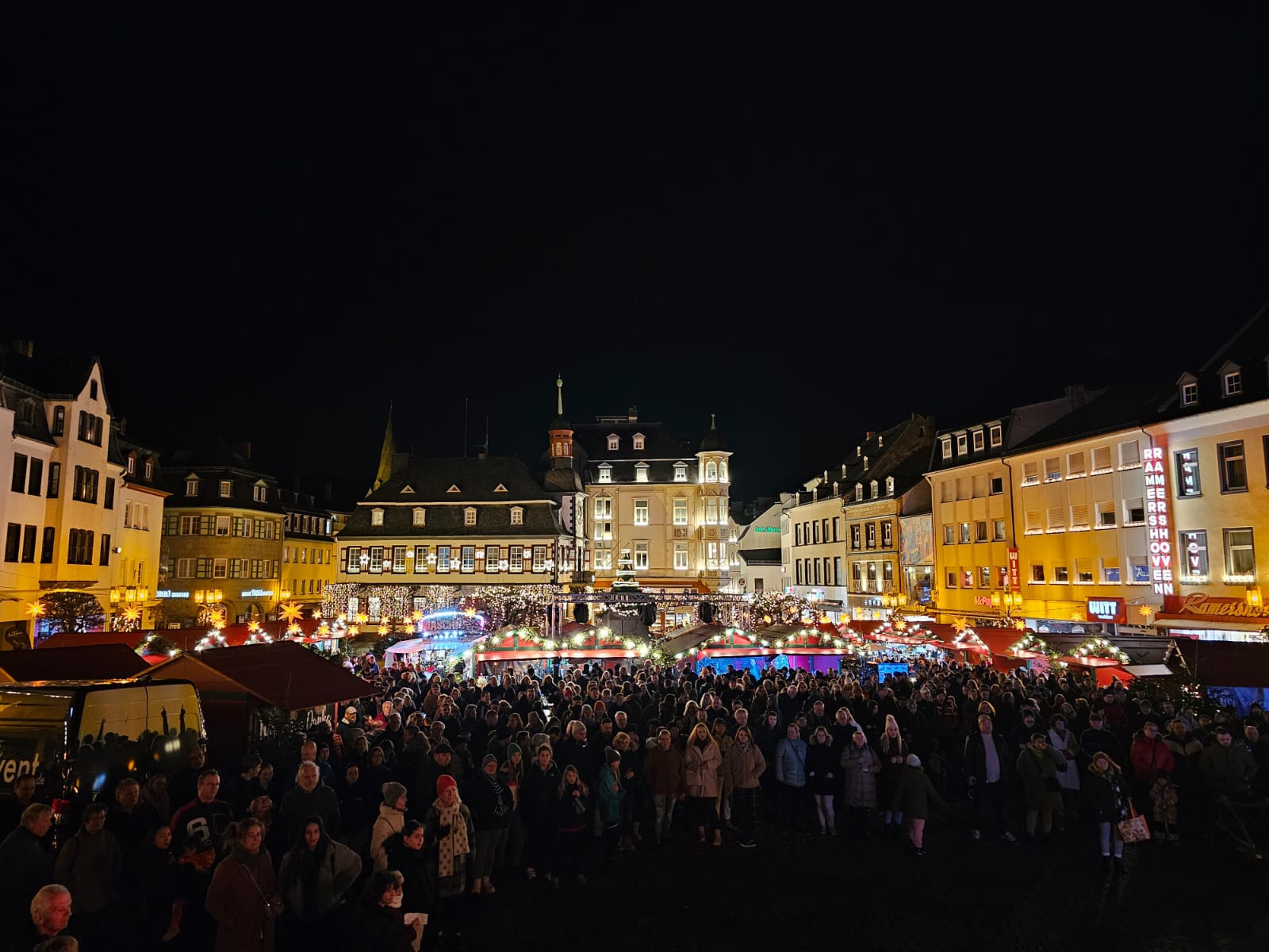 Weihnachtsmarkt mit vielen Besucherinnen und Besuchern. Im Hintergrund sind die Stände und das Alte Rathaus zu sehen.