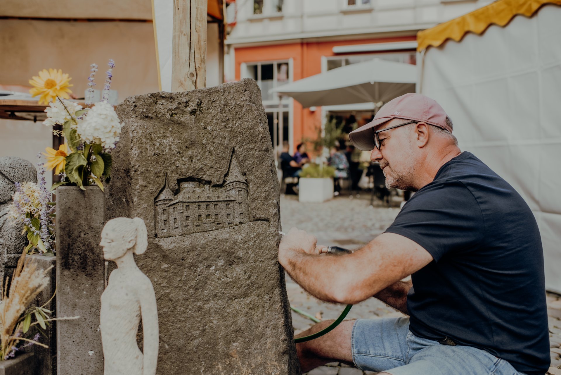 Stein- und Burgfest ein Bildhauer, der mit Hammer und Meißel einen Stein bearbeitet