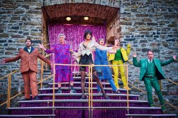 6 Personen stehen verteilt auf einer Treppe in Pose