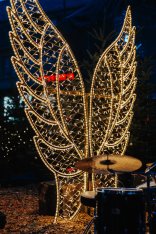 Menschen, die über den Weihnachtsmarkt mit seinen roten Verkaufshäuschen schlendern