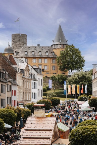 Viele Menschen und Trödelstände mit Blick auf die Burg