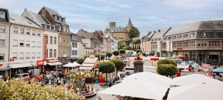 Viele Menschen und Trödelstände mit Blick auf die Burg