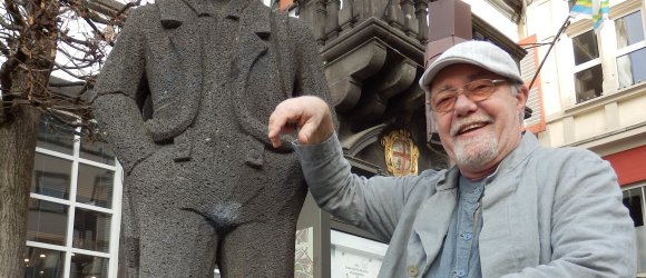 Wilfried Eckert in seiner Rolle als Layer Jupp mit der Mayener Jung Figur vor dem Alten Rathaus