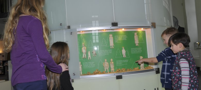 Ebene 0 3 Kinder schauen sich eine Ausstellungsfläche auf der Ebene 0 an