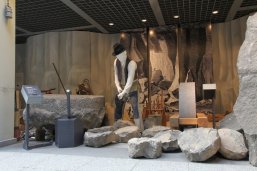 Einblick in die Ausstellungshalle Steinzeiten, man sieht die Figur eines Steinarbeiters bei der Arbeit.