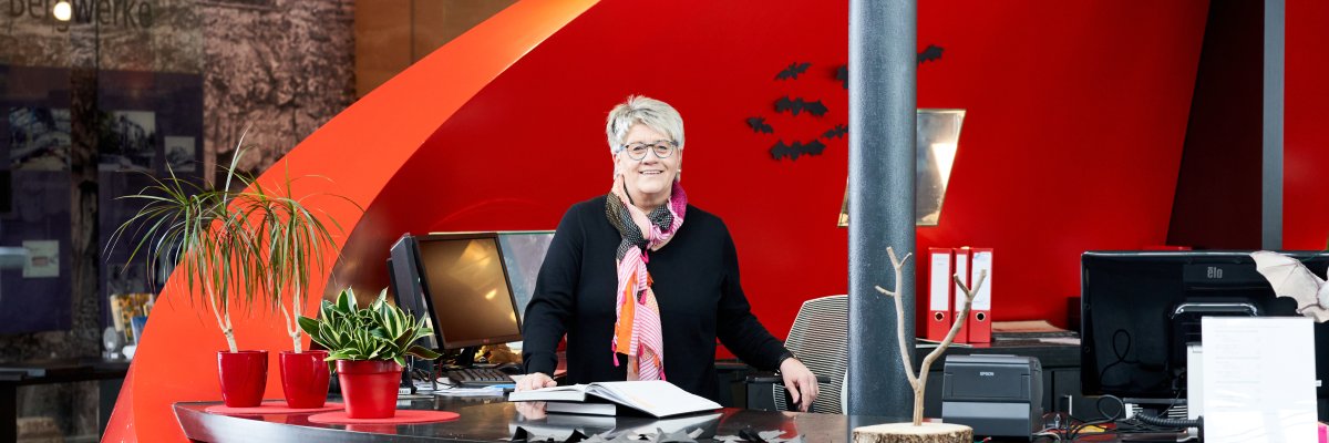 Frau steht an der Rezeption der Erlebniswelten Grubenfeld