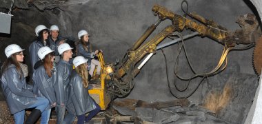 Familie im Schieferbergwerk mit einem Bagger