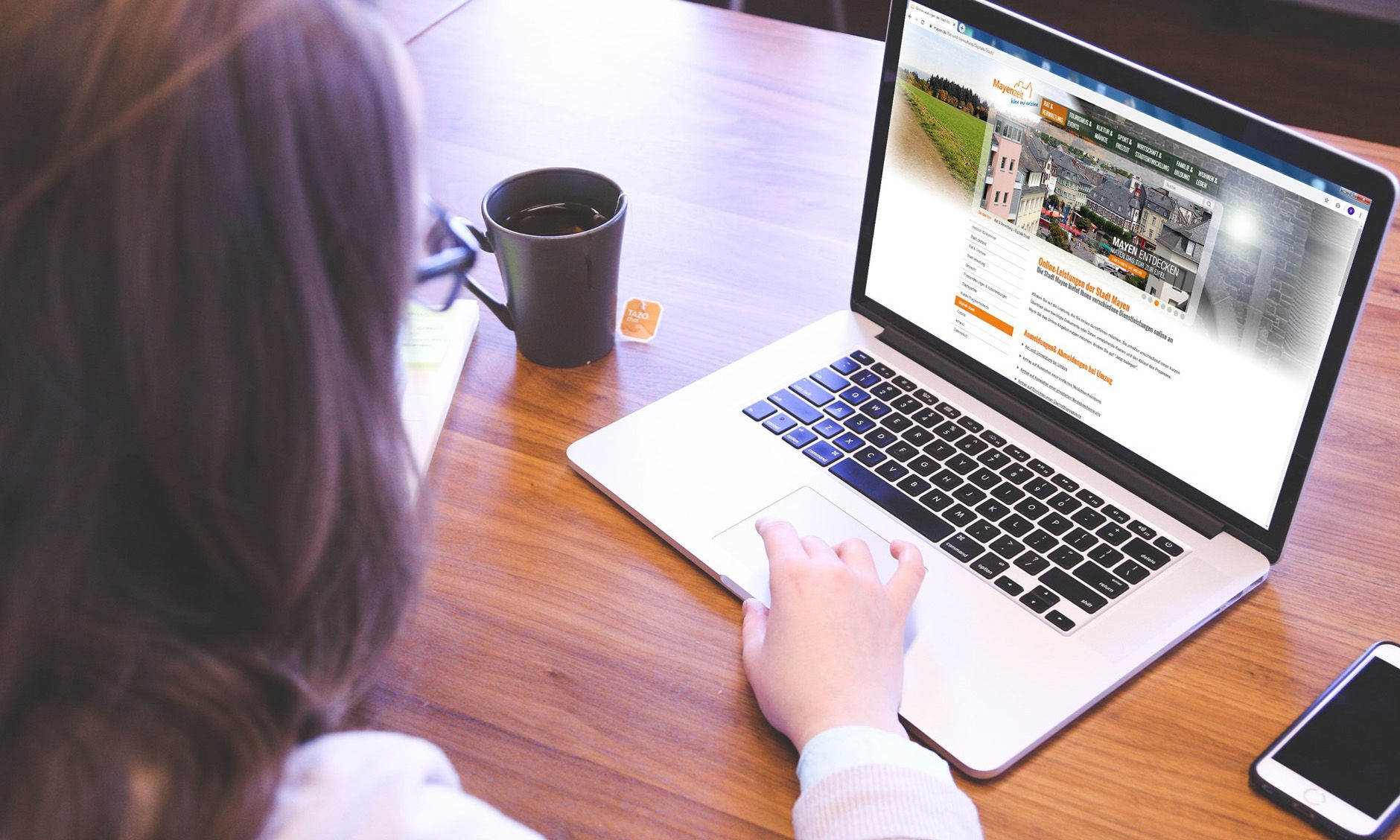 Frau sitzt am Laptop und nutzt die digitalen Dienstleistungen der Verwaltung