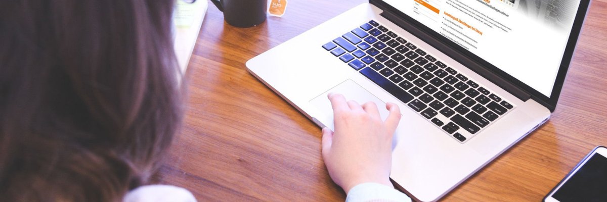 Frau sitzt am Laptop und nutzt die digitalen Dienstleistungen der Verwaltung
