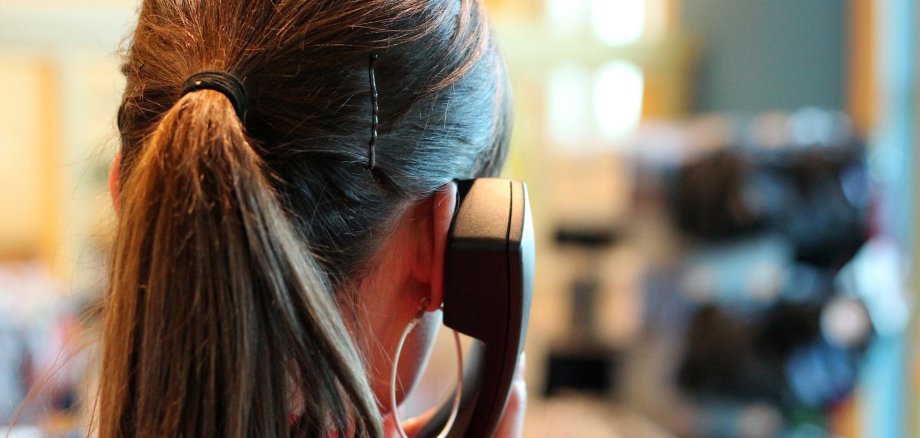 Telefonierende Frau von hinten Ansicht einer telefonierenden Frau von hinten