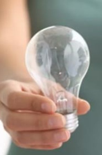 Person hält links eine Glühbirne, rechts eine Energiesparlampe in der Hand