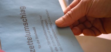 Hände mit Briefwahlunterlagen Hände mit Briefwahlunterlagen