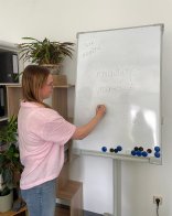 Verwaltungsfachangestelle Frau steht an Flipchart und notiert etwas