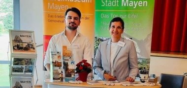 2 Personen stehen an einem Messestand