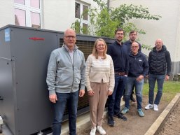 Wärmepumpe Grundschule St. Veit Viele Personen stehen vor der Wärmepumpe und schauen sich diese an