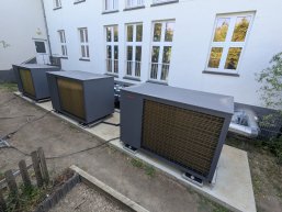 Am Gebäude der Grundschule St. Veit stehen drei Wärmepumpen nebeneinander