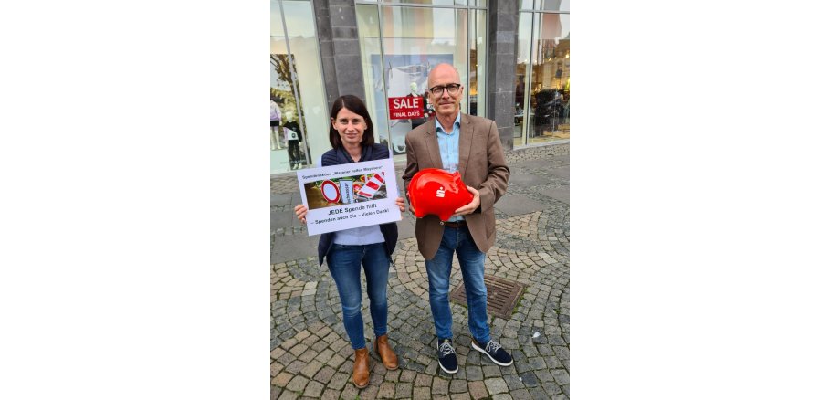 Wirtschaftsförderung Christina Wolff mit Oberbürgermeister Dirk Meid halten rotes Spendenschwein n der Hand