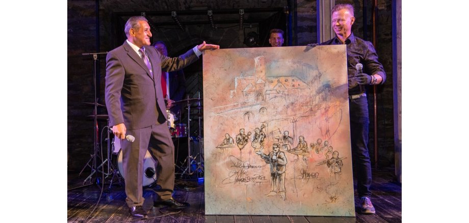 Django Reinhardt und Matthias Scheidig zeigen das Gemälde auf der Bühne