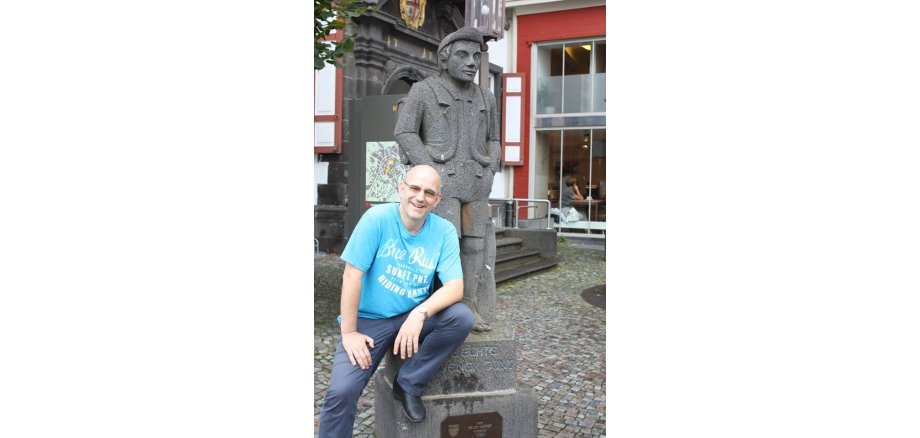 Werner Blasweiler sitzt am Mayener Jung vor dem Alten Rathaus