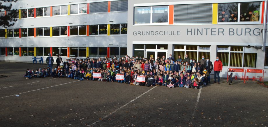 Viele Schülerinnen und Schüler vor dem Gebäude der Grundschule Hinterburg