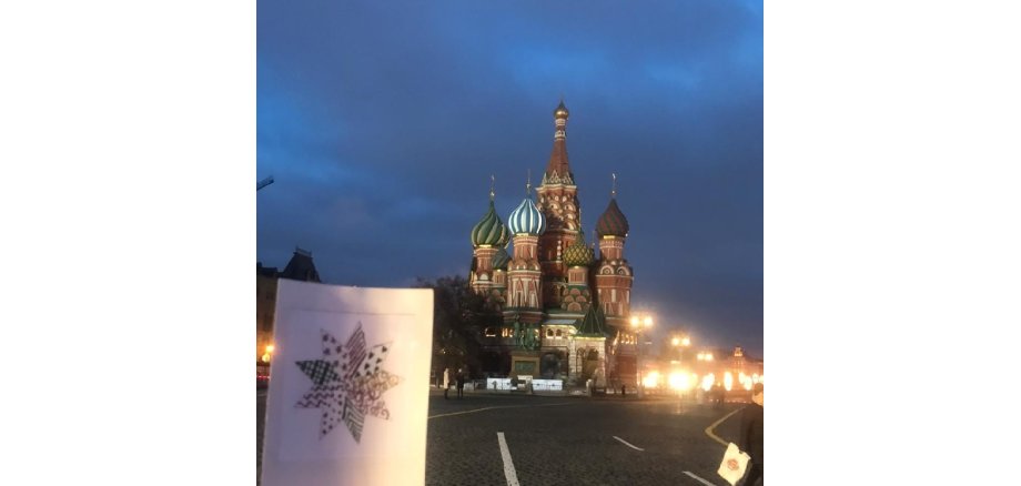 weiße Karte mit Stern im Dunkeln abgelichtet vor der Basilius Kathedrale in Moskau