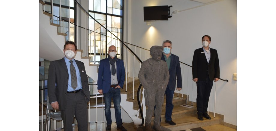 4 Personen mit Mund-Nasen-Schutz stehen im Eingangsbereich innen der Stadt Mayen und begrüßen neuen Kollegen 