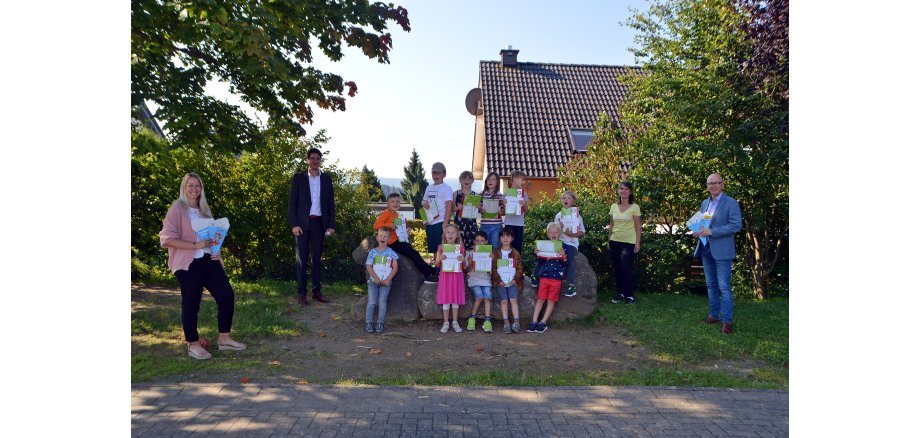 Die Erstklässler der Grundschule Kürrenberg freuen sich gemeinsam mit Dirk Meid, Oberbürgermeister der Stadt Mayen und Fabian Vocktmann, Regionalmanager bei Westnergie, über die Schulheftpakete.