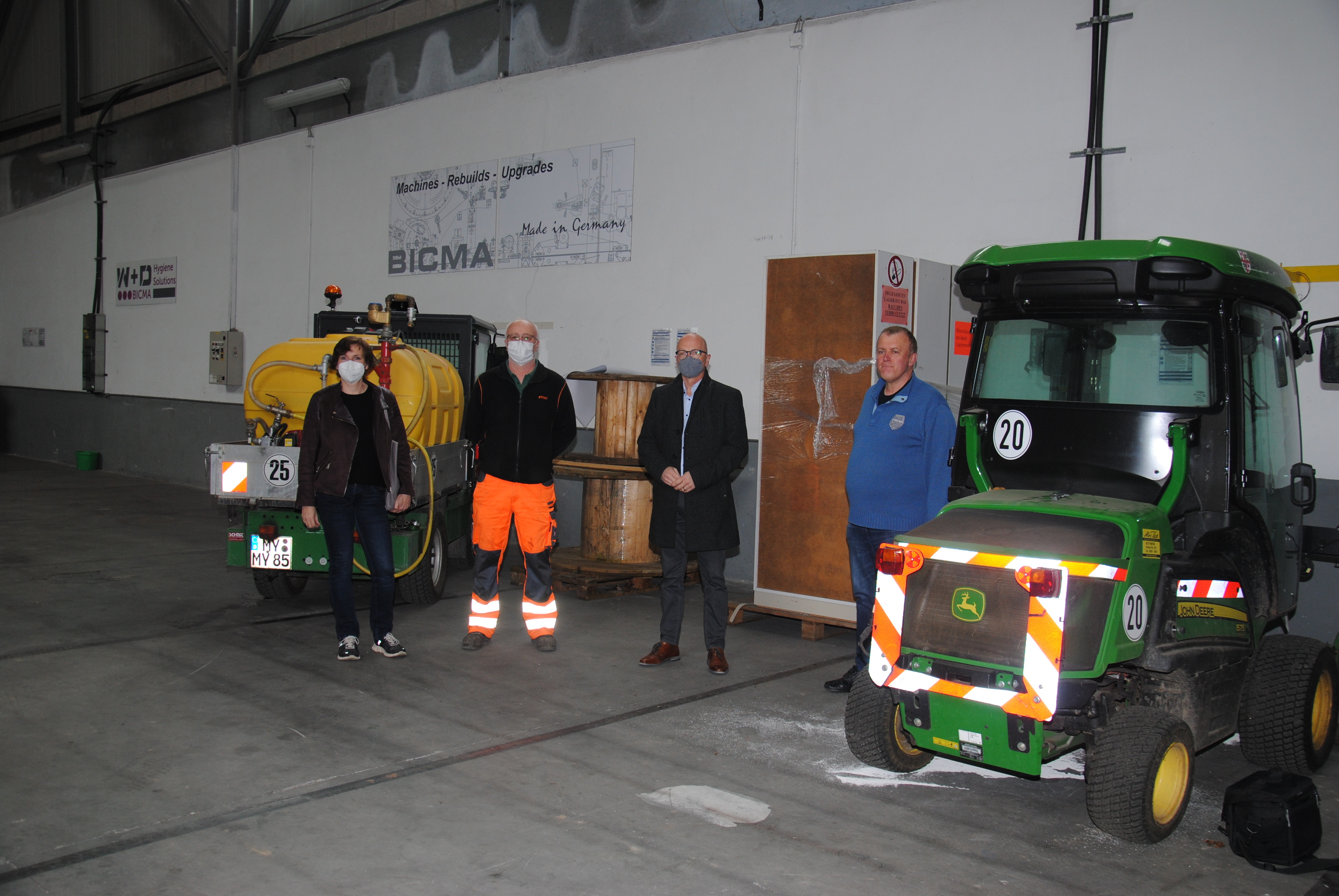 Martina Ackermann, Alexander Bader, Oberbürgermeister Dirk Meid und Horst Helmes zwischen zwei Arbeitsgeräten der Stadt Mayen