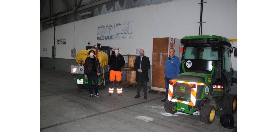 Martina Ackermann, Alexander Bader, Oberbürgermeister Dirk Meid und Horst Helmes zwischen zwei Arbeitsgeräten der Stadt Mayen