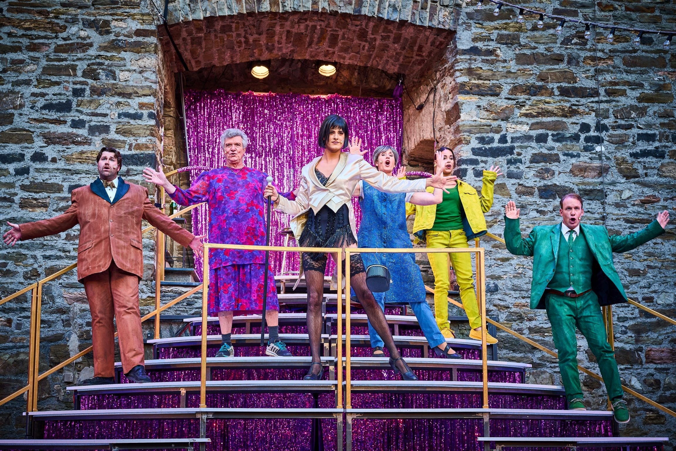 Mehrere Schauspieler stehen versetzt auf der Treppe