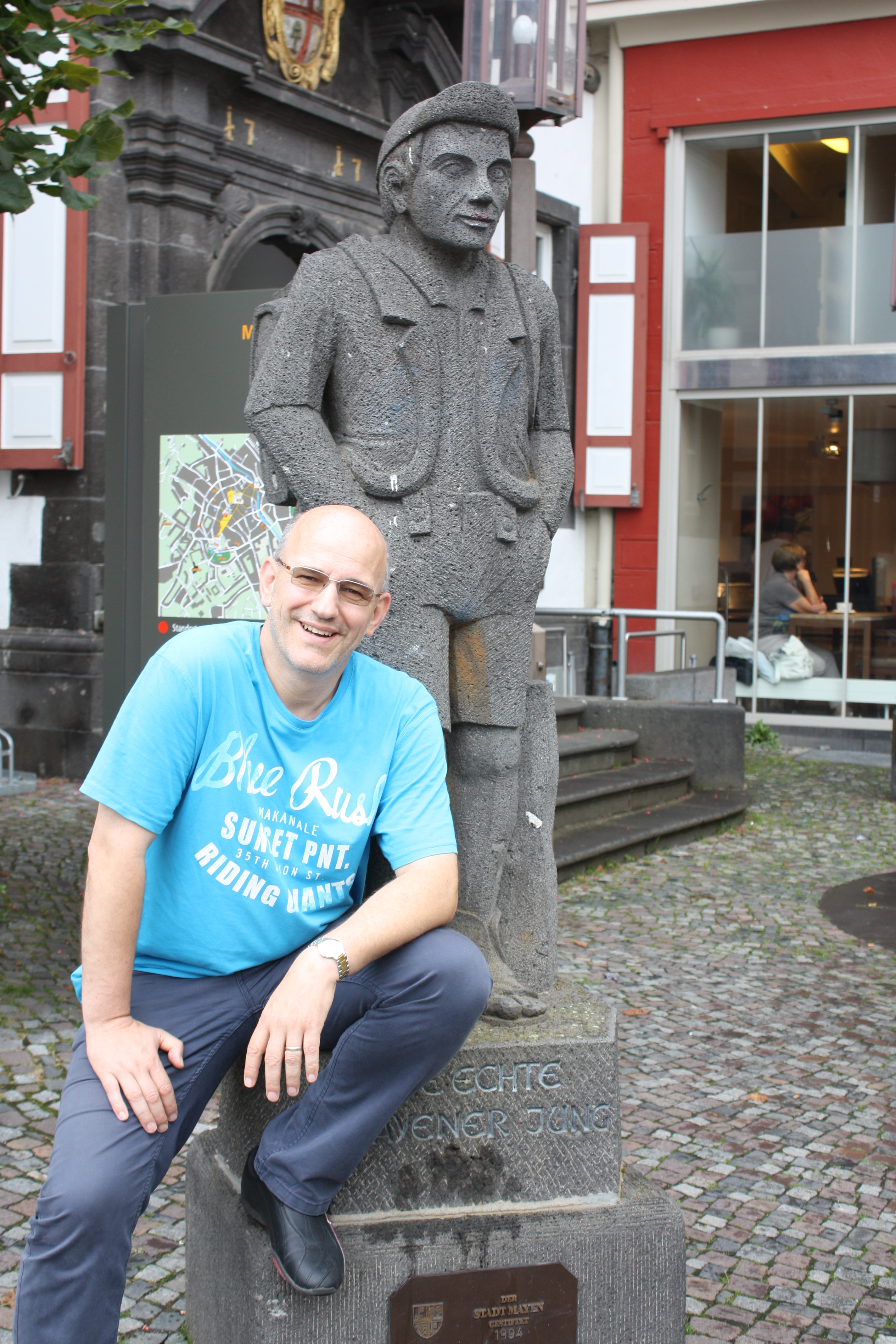 Ein Mann sitzt vor dem Mayener Jung am Marktplatz