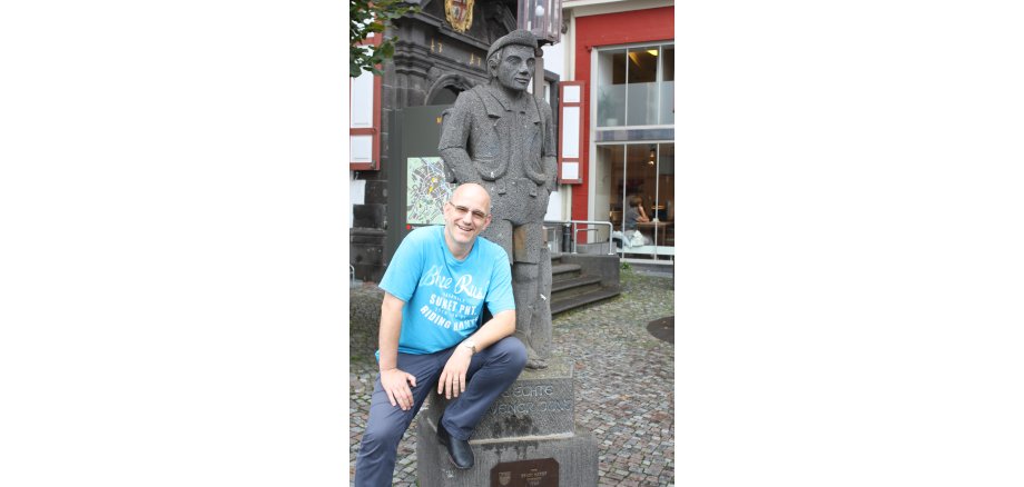 Ein Mann sitzt vor dem Mayener Jung am Marktplatz